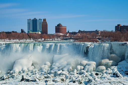 Partially frozen American waterfalls part of Niagara Falls and US side view from Canada