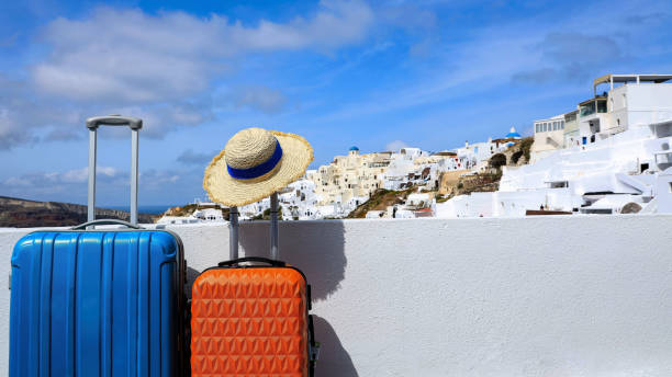 dwa bagaże z kapeluszem i widokiem na miasto oia na wyspie santorini w grecji, grecki krajobraz jako błękitne niebo tło - hat oia europe vacations zdjęcia i obrazy z banku zdjęć