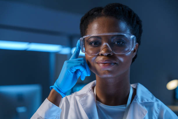 A close -up of a young beautiful African-American lab assistant in protective glasses in a modern laboratory stock photo
