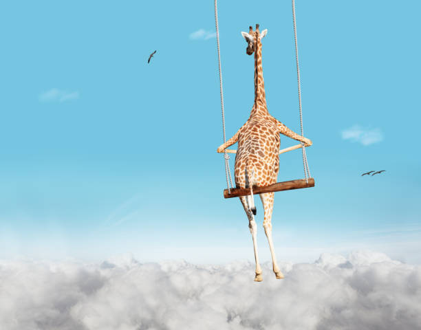 istock Giraffe swinging on swing bar over blue sky with clouds 1394199441