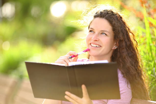 une femme prête à écrire dans un cahier - writing diary nature ideas photos et images de collection