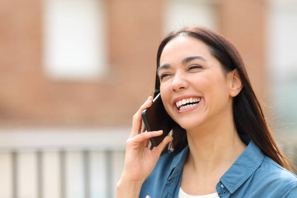 istock Happy woman laughing while is talking on phone 1394200521