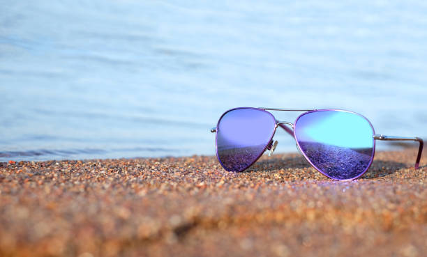 istock Purple sunglasses on a sand beach, seaside, copy space 1394202097