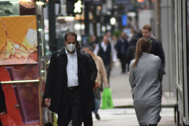 peatones enmascarados y desenmascarados en nueva york - unmasked fotografías e imágenes de stock