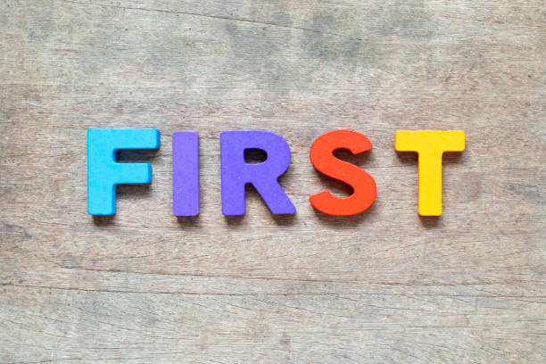 istock Color alphabet letter with word first on wood background 1394209752