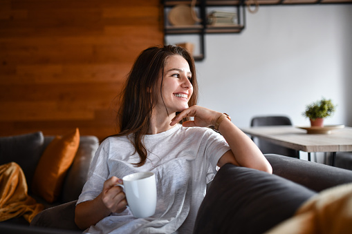 Smiling Female Beauty Enjoying Coffee Time And Looking Through Window