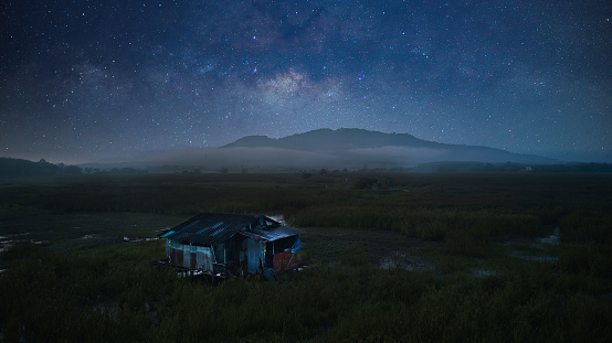 Beautiful milky way and a single house was built in a wetland located in a rural