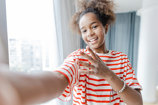 Portrait of African American teenage girl looking at front mobile phone camera