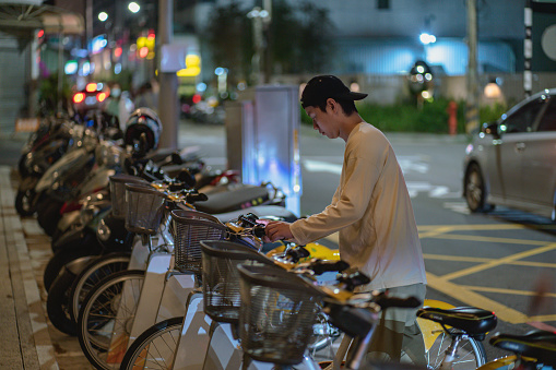 Asia, in the evening, a young Taiwanese boy rented a bicycle to go home.