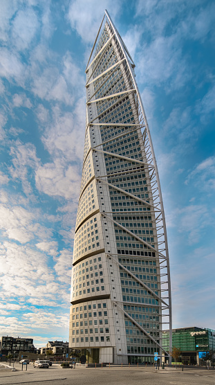Malmo, Sweden - 09.19.2016: Cityscape Turning Torso skyscraper - Malmö symbol and landmark - the tallest building in Scandinavia. Beautiful Vertical photo with sky and clouds.