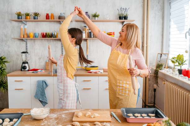istock Mother And Daughter Singing And Dancing While Baking In The Kitchen 1394228775