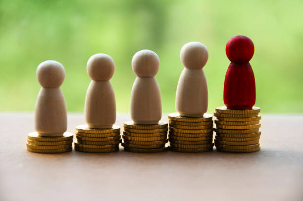 istock Wooden dolls standing on stack of gold coins. Copy space 1394229523