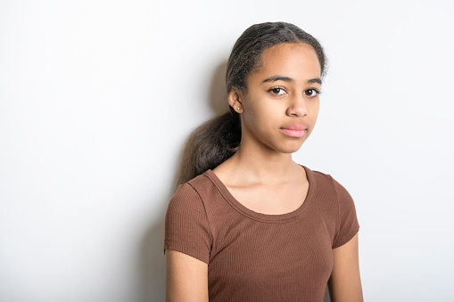 A Beautiful black teen posing on studio white background looking sad