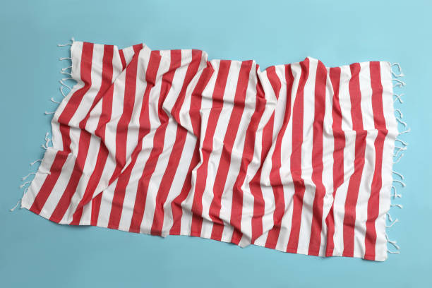 istock Crumpled striped beach towel on light blue background, top view 1394229737