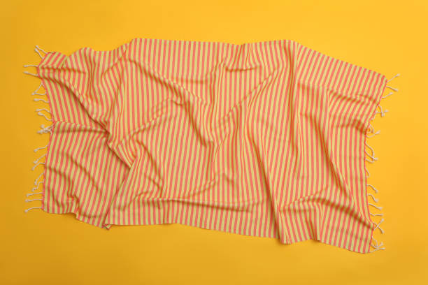 istock Crumpled striped beach towel on yellow background, top view 1394231088