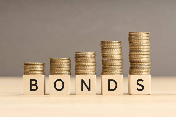 Bonds word in wooden blocks with coins stacked in increasing stacks Bonds word in wooden blocks with coins stacked in increasing stacks. Bonds increasing concept. Copy space bonding stock pictures, royalty-free photos & images