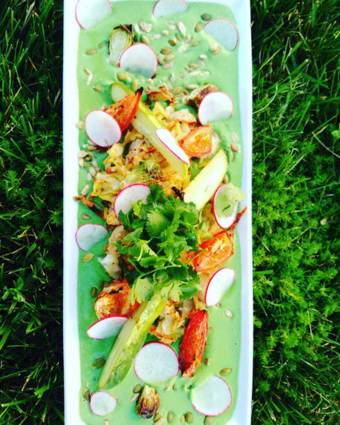 Top view of  green pea cream with roasted vegetable salad