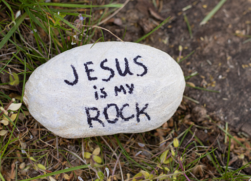 Jesus is my rock, a handwritten text, bible verse on a stone in nature. Christian biblical concept. A close-up.