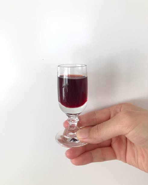 sosteniendo a mano un vaso antiguo de licor de aronia - liqueur glass fotografías e imágenes de stock