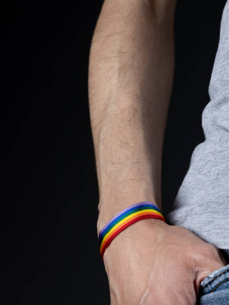 istock Hand with LGBT rainbow pride bracelet. Black background 1394236835