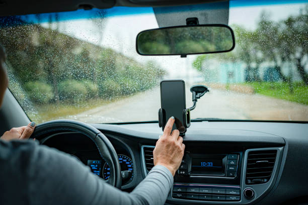 istock Woman touching smartphone screen while driving car 1394236956