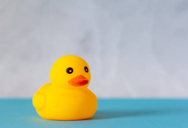 istock Rubber duck on marble blue background with copy space. 1394238544