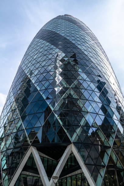 The Gherkin or St Mary Axe building in the city of London. This iconic structure is home to many global businesses such as Sky News and Swiss Re. London, UK - 18 April 2022: The Gherkin or St Mary Axe building in the city of London. This iconic structure is home to many global businesses such as Sky News and Swiss Re. sky news stock pictures, royalty-free photos & images