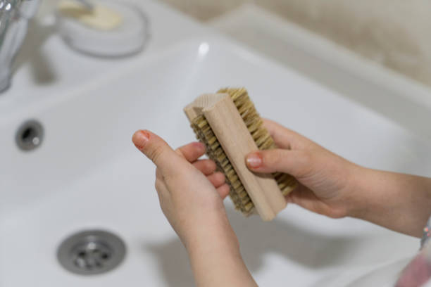 Close up view of little girl scrubbing hands at bathroom sink (selective focus)