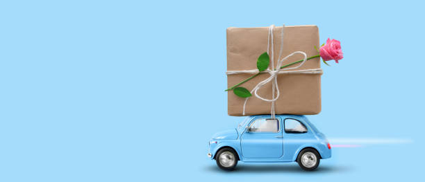 istock Blue toy car with gift box and rose flower atop. 1394242599