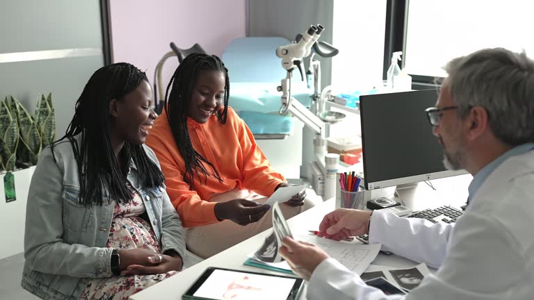 Excited pregnant woman looking at sonogram image with her partner