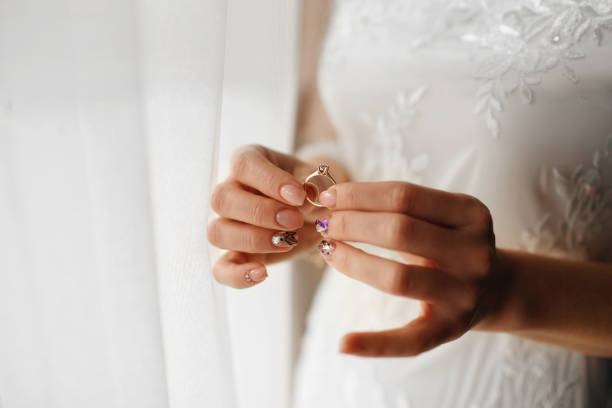istock beautiful bride holds a wedding ring with a diamond in her hands 1394250241