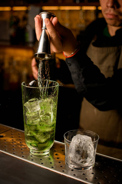 istock hand of the bartender pours drink from jigger into mixing cup with ice 1394250756