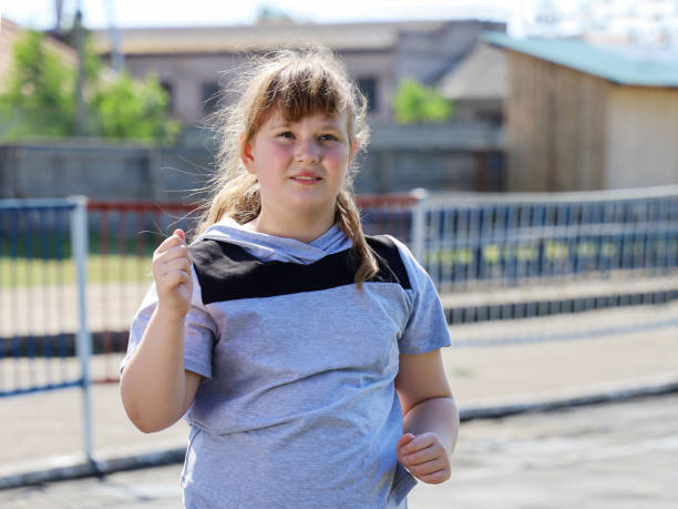 chubby girl in sportswear runs in for sports, close-up portrait - child obesity imagens e fotografias de stock