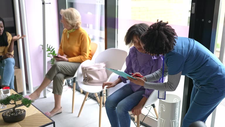 Nurse filling out a questionnaire during a consultation with a patient