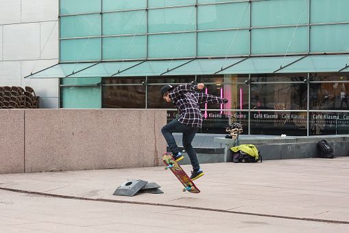 Helsinki, Finland, April, 14, 2011, skatebarder jumping in front of a modern glass building