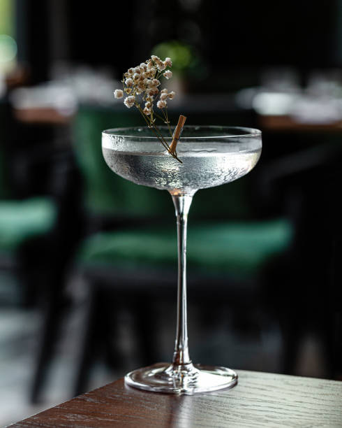 Glass goblet of transparent cocktail garnished with flowers Refreshing cold transparent cocktail in glass gin photos stock pictures, royalty-free photos & images