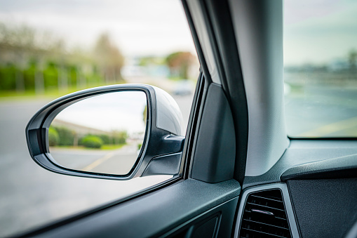 Close up view of external rear-view mirror shot from car interior. Selective focus on mirror. High resolution 42Mp outdoors digital capture taken with SONY A7rII and Zeiss Batis 40mm F2.0 CF lens