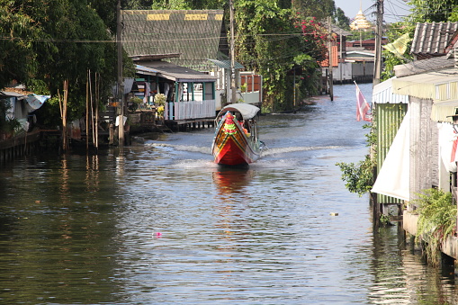 Long-tailed boat is sailing in canal, Bangkok, Thailand.