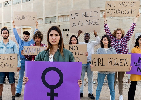 Multiracial group of protesters marching on the street with signboards for equality and woman empowerment. Feminism concept. Woman's day concept.