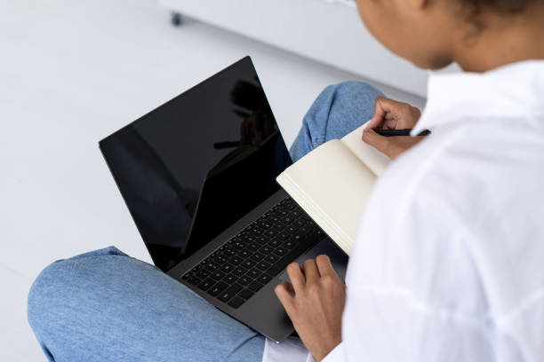istock African american lady looking at laptop and making notes 1394261035