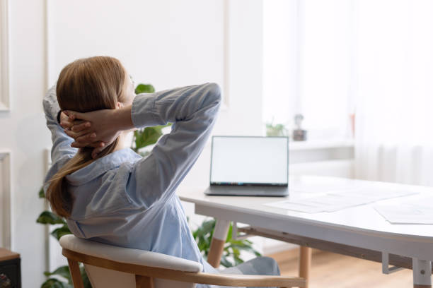 istock Woman crossing hands behind head during work 1394261427