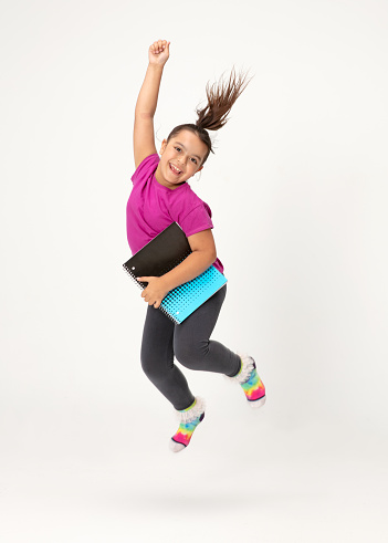 Young Hispanic girl jumping. Shot in studio