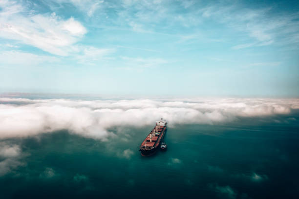 luftaufnahme des frachtschiffes, das sich mit einem schlepper dem hafen nähert. - piloting commercial dock harbor industrial ship stock-fotos und bilder