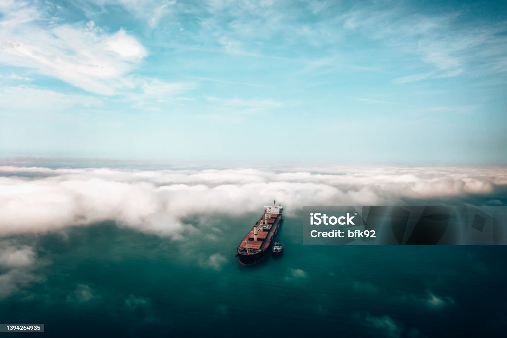 Aerial view of Cargo Ship approaching port with tugboat. Harbour tugboat guides a cargo ship into the harbour of Samsun - Turkey - Taken with DJI Mavic 2 Pro, You can see more shipping concept images in my portfolio. Aerial drone view of a container ship nearing port with the assistance of a tugboat Ship Stock Photo