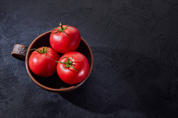 istock Red, ripe tomatoes in bowl on a dark background. Harvesting fresh tomatoes. 1394265203