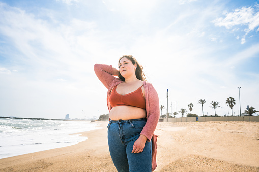 Beautiful and cheerful plus size young woman outdoors - Pretty overweight curvy female, concepts about femininity, women power, female emancipation, body positivity and body acceptance