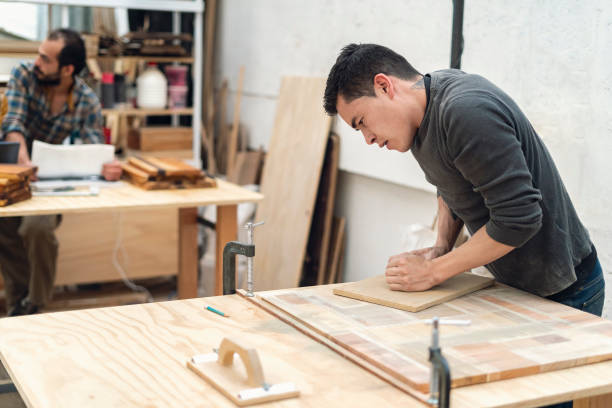 istock Carpenter sands a piece of wood. 1394268060