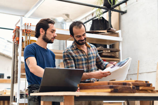 istock Carpenters looking at notebook where their work things are 1394268091