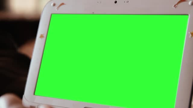 White Netbook Computer with Green Screen. Zoom In. Close Up.