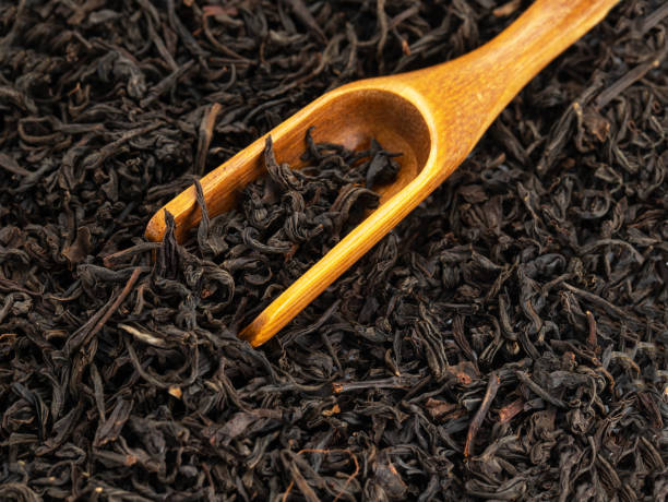 istock dry black tea leavs background and wooden spoon 1394276457
